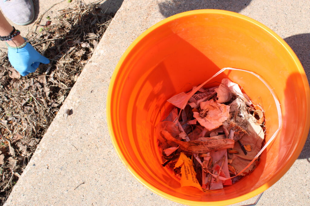 There is an orange bucket with collected litter that covers the bottom. 